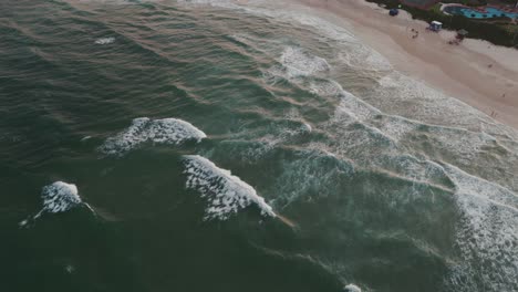 Eine-Vogelperspektive-Des-Brava-Strandes-In-Florianopolis,-Brasilien,-Mit-Wellen,-Die-Sich-Bei-Sonnenuntergang-Am-Ufer-Brechen