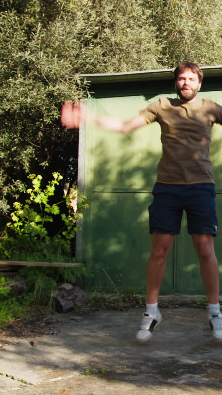 Young Athlete Does Jumping Jacks Under The Trees In The Countryside