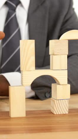 businessman playing with building blocks