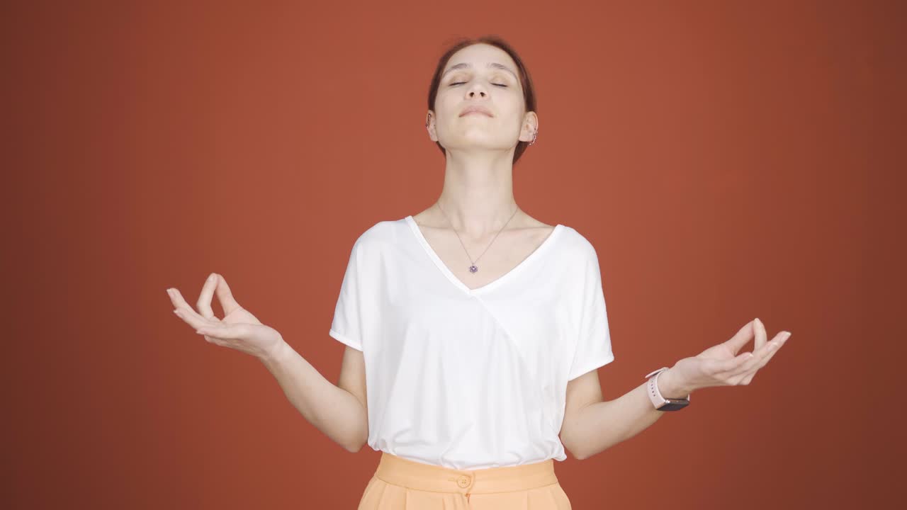 una mujer meditando mirando a la cámara.