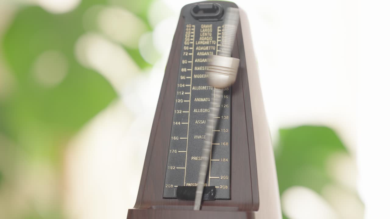 Vintage metronome in motion with pendulum swinging