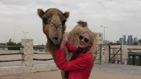 woman embraces camel