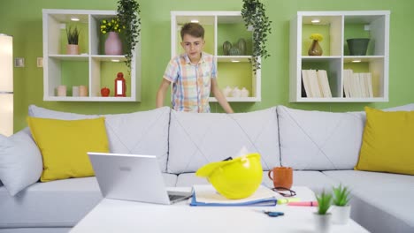 funny boy playing with his engineer father's work items.