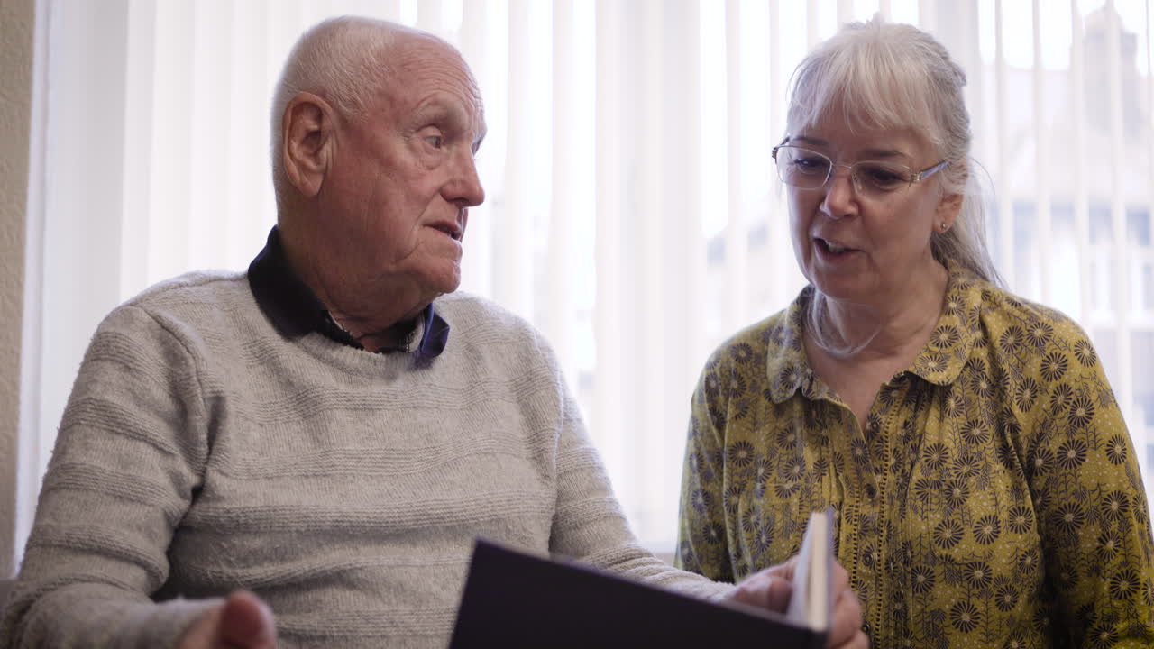 una pareja de ancianos leyendo un libro