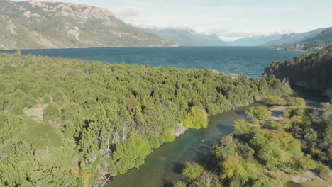 beautiful wide angle aerial view of a large lake sitting before the mountains in argentina