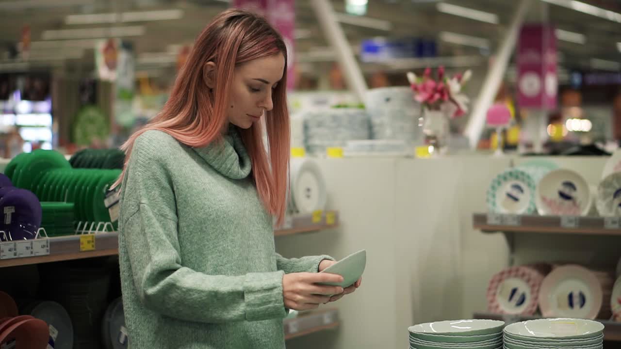 mujer comprando vajilla, eligiendo tazón de sopa en el supermercado