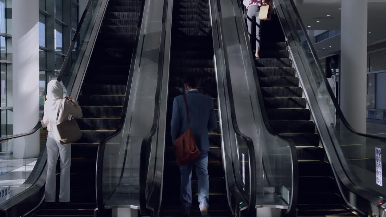 현대 사무실 4k에서 에스컬레이터를 사용하는 비즈니스 사람들