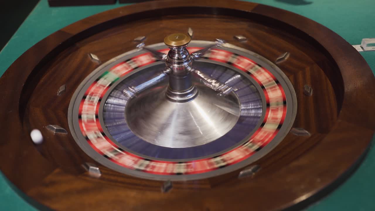 un hombre girando una rueda de ruleta y dejando caer la bola en la rueda