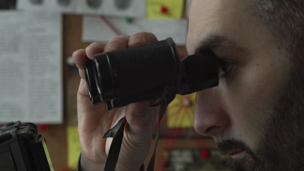 detective o espía mirando a través de binoculares y capturando la escena del crimen, vista lateral de cerca del ojo y la cara