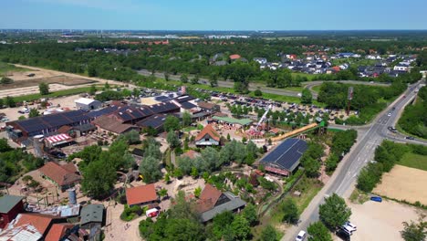 amusement park with roller coasters, various attractions, and green spaces in germany. speed ramp hyper motion time lapse. lovely aerial view flight wide orbit overview drone
