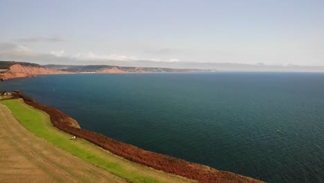 Aerial-Dolly-Back-Across-English-Channel-Over-Field-Coastal-Path