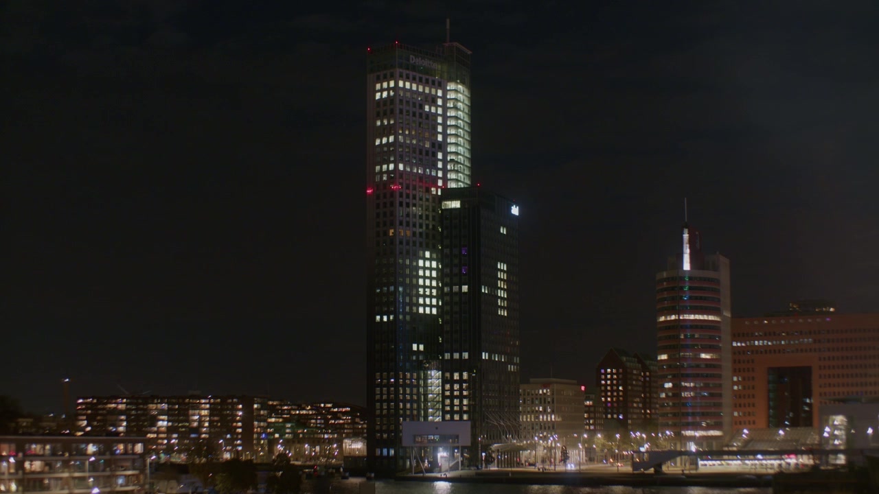 Cidade escura noturna de Roterdã, na Europa, Holanda, em estilo holandês moderno com luzes, água e edifícios com arranha-céus piscando no topo.