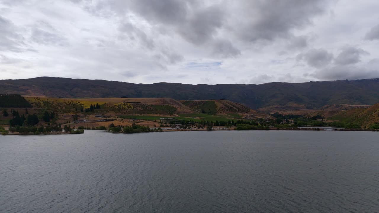 озеро данстан в центральном отаго с облачным небом и неровной местностью, вид с воздуха