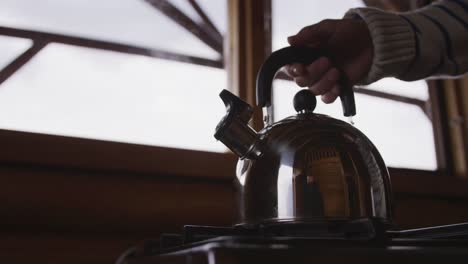 caucasian hand man spending time at home, taking a kettle