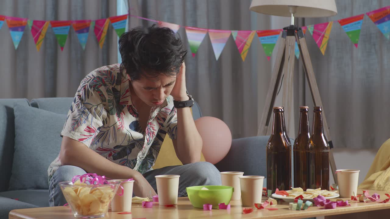 집 에서 파티 를 축하 한 후 소파 에 앉아 있는 술 취한 아시아인