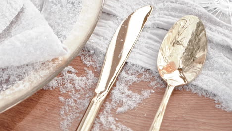 golden cutlery arranged on wedding table with winter theme decoration, close up