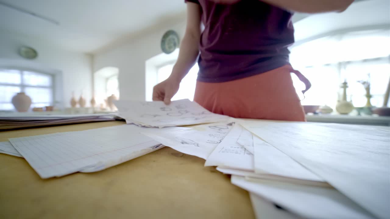 Person Reviewing Sketches in an Art Studio