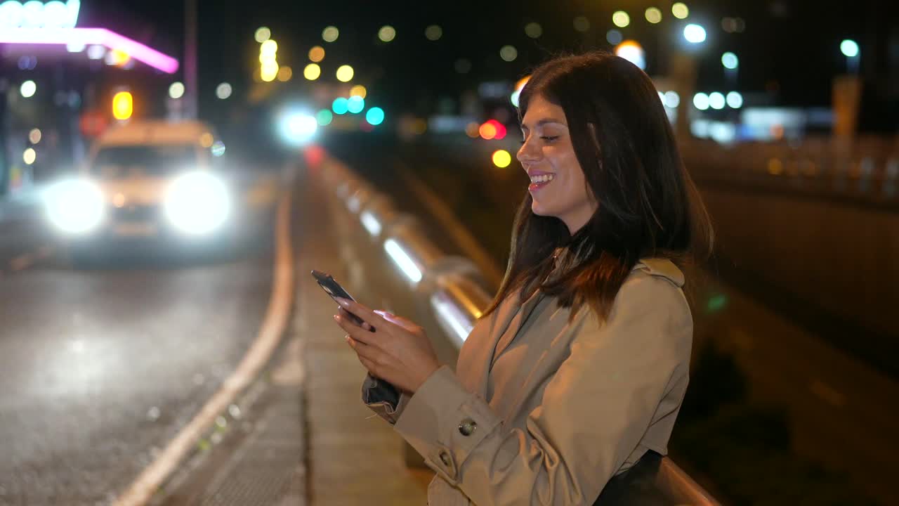 Woman using mobile phone at night in the city