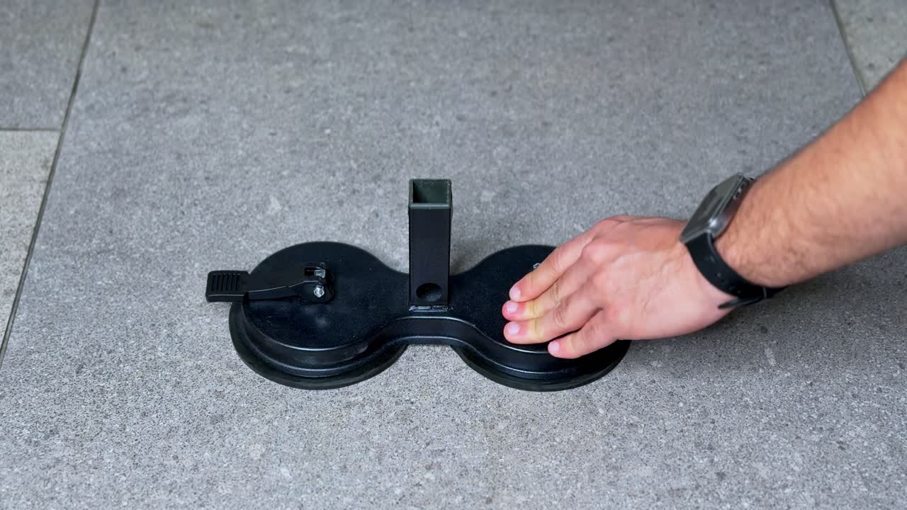 4K close-up of hands assembling suction cup resistance fitness gear on a stone floor. Ideal for workout tutorials, home gym setup, or fitness equipment B-roll.