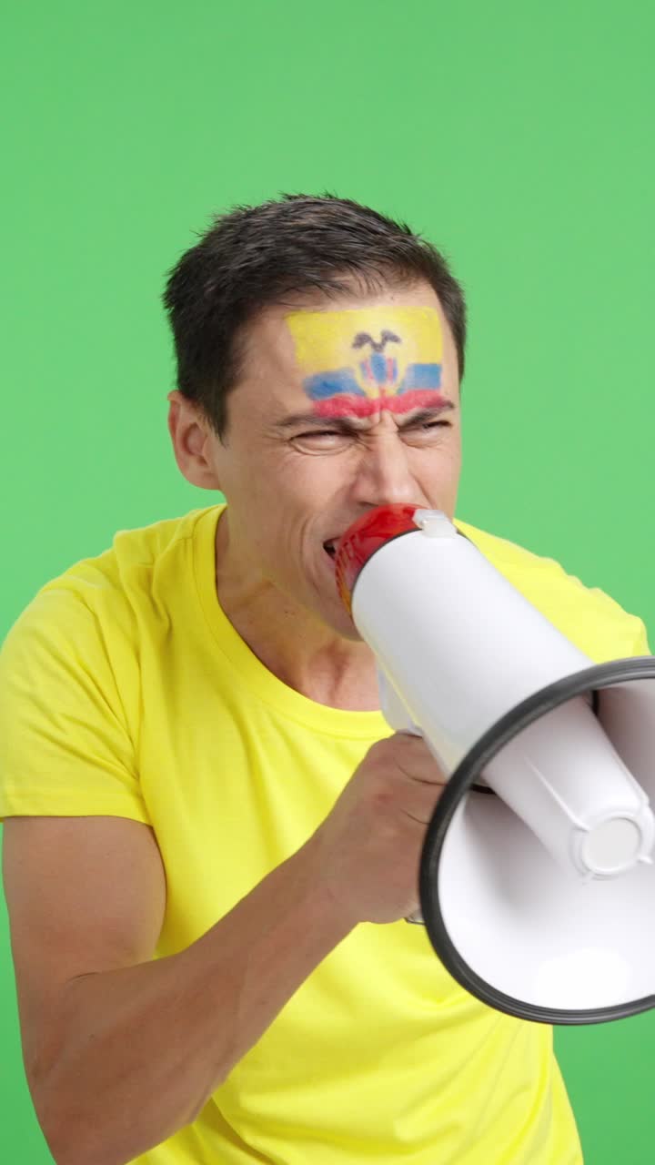 Excited man with ecuadorian flag on face using a megaphone