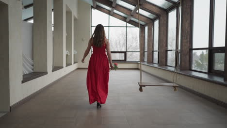 woman in red dress walking towards the camera