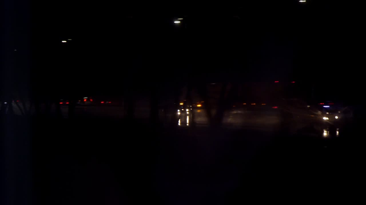 Gocce di pioggia sul finestrino. Ferrovia. Autostrada trafficata di notte. Luci dei fari delle auto