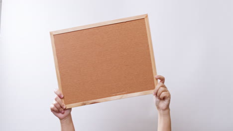 la mano de la mujer muestra el tablero vacío en el fondo del estudio blanco con espacio para copiar