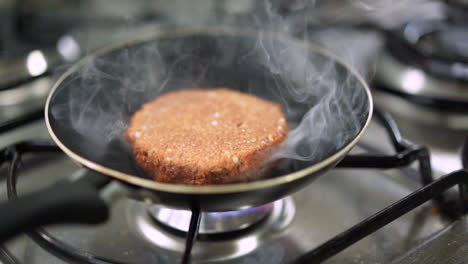 hermosa hamburguesa a base de plantas veganas en cámara lenta cocinando en una sartén