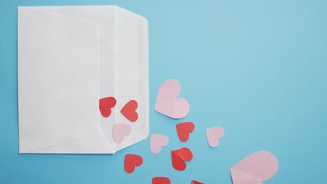 Umschlag-Mit-Roten-Und-Rosa-Papierherzen-Am-Valentinstag-Auf-Blauem-Hintergrund