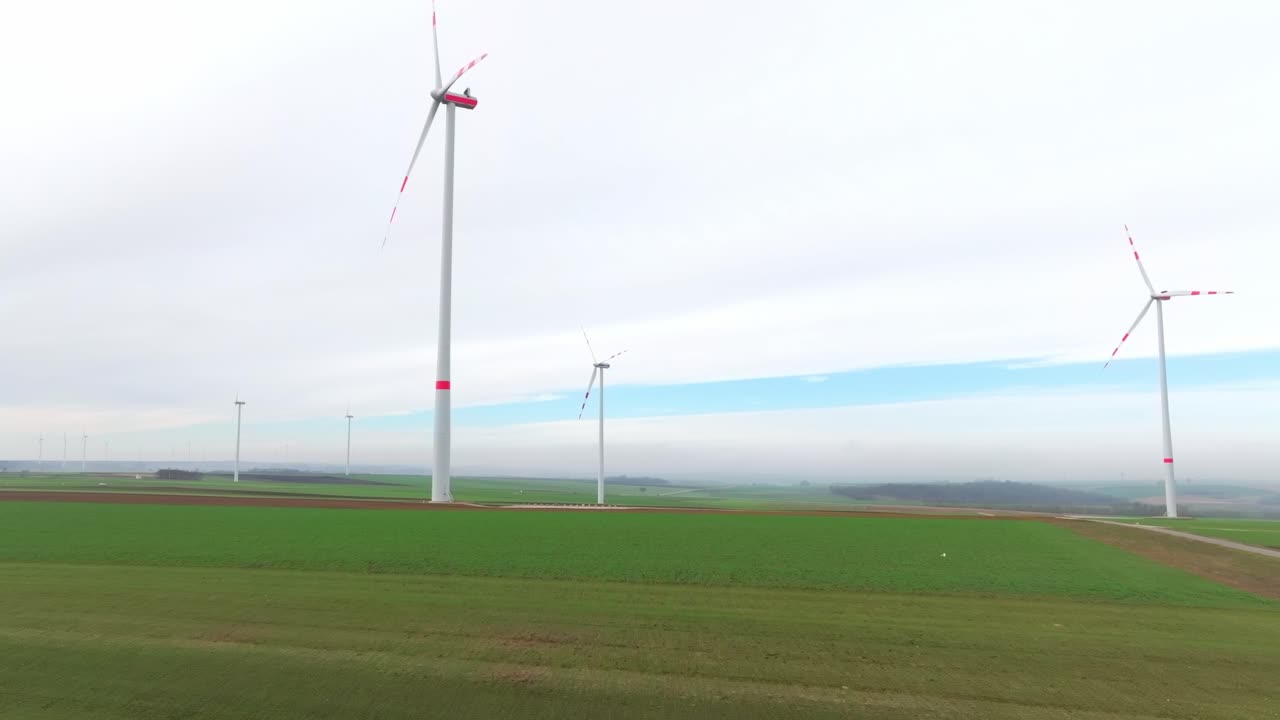 풍력 터빈은 초록색  위에 높게 서 있습니다.