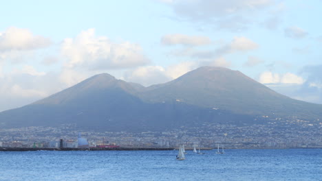 Vista-Del-Monte-Vesubio-Y-La-Ciudad-De-Nápoles,-Veleros-Navegando-En-Primer-Plano.