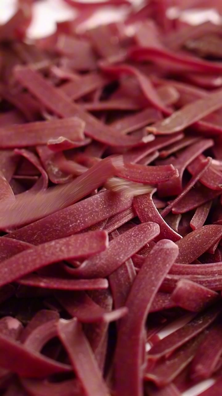 Raw Beetroot Pasta Falling onto a Pile