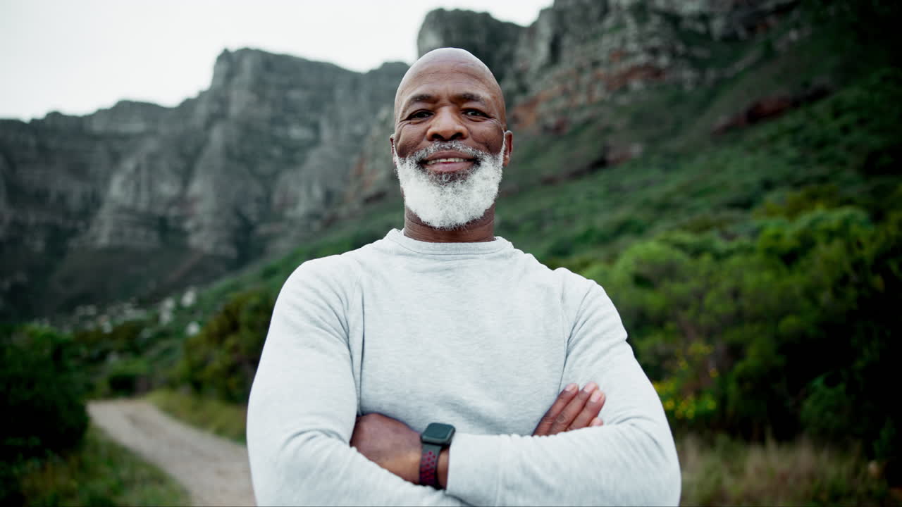 Portrait of a smiling man on a trail in front of mountains