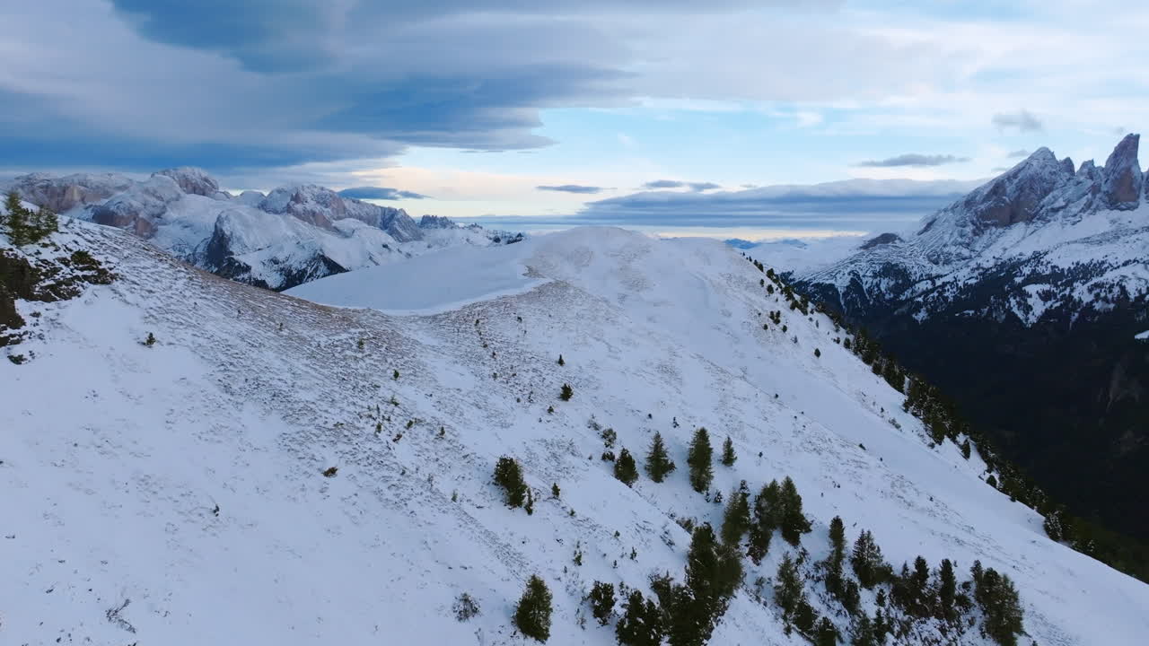 video aéreo volando sobre la cresta cubierta de nieve de una montaña en lo alto de los dolomitas en italia.