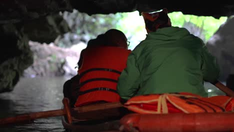 los turistas exploran la cueva en barco, tomando fotos