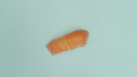 un rollo de sushi girando sobre un fondo azul