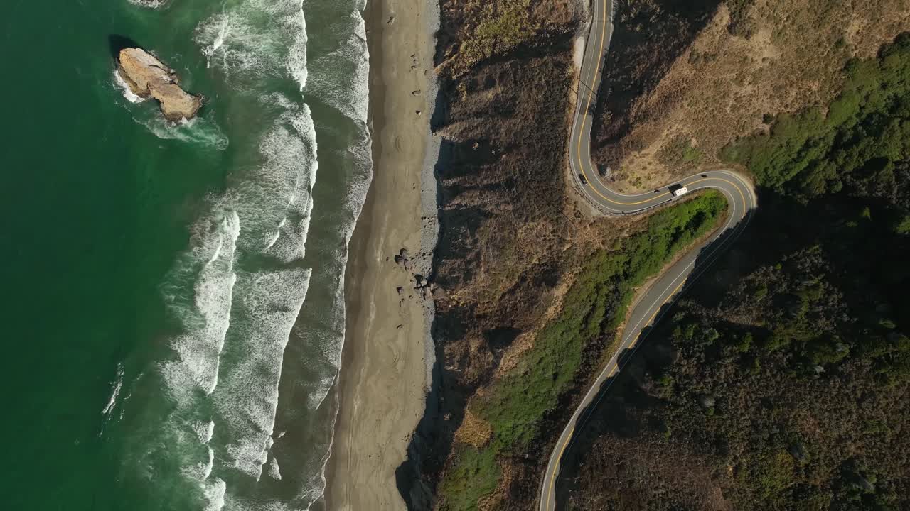 vista aérea de arriba hacia abajo de los autos que conducen paralelos a las playas de california en una carretera escénica