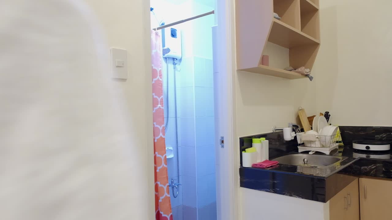 샤워 커튼을 열고 목욕 후 욕실에서 빠져나오는 젊은 여성