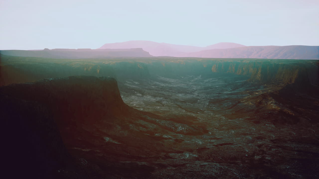 Vast canyon landscape with distant mountains at sunset in serene colors