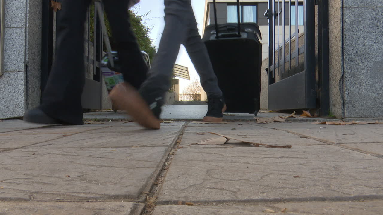 Couple Walking Through Gate With Luggage