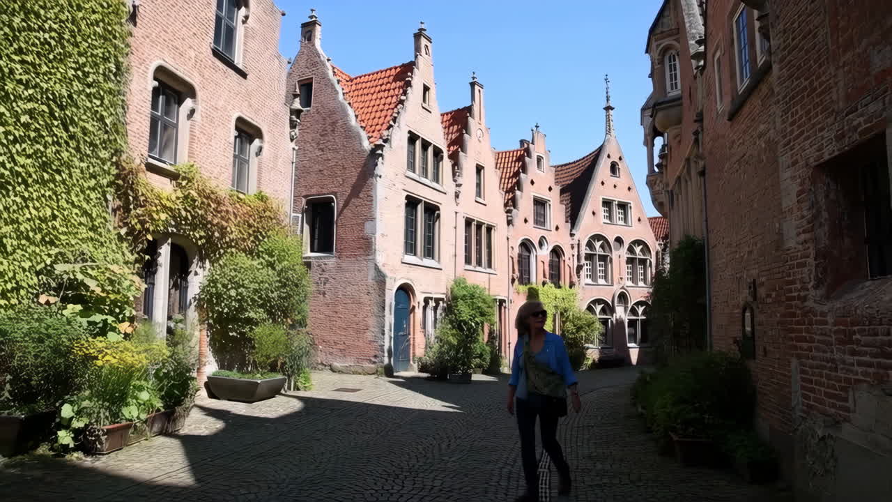 Woman Walking on a Cobblestone Street in a Historic European Town