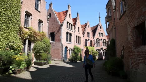 Woman Walking on a Cobblestone Street in a Historic European Town
