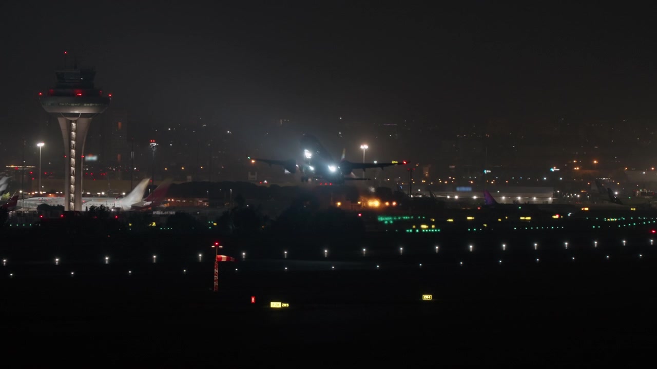 管制塔と滑走路のライトが輝く夜の空港。