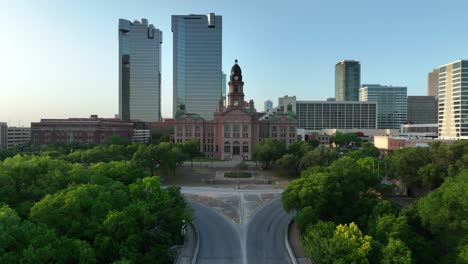 Aerial-push-in-from-straight-road-towards-old,-large-courthouse