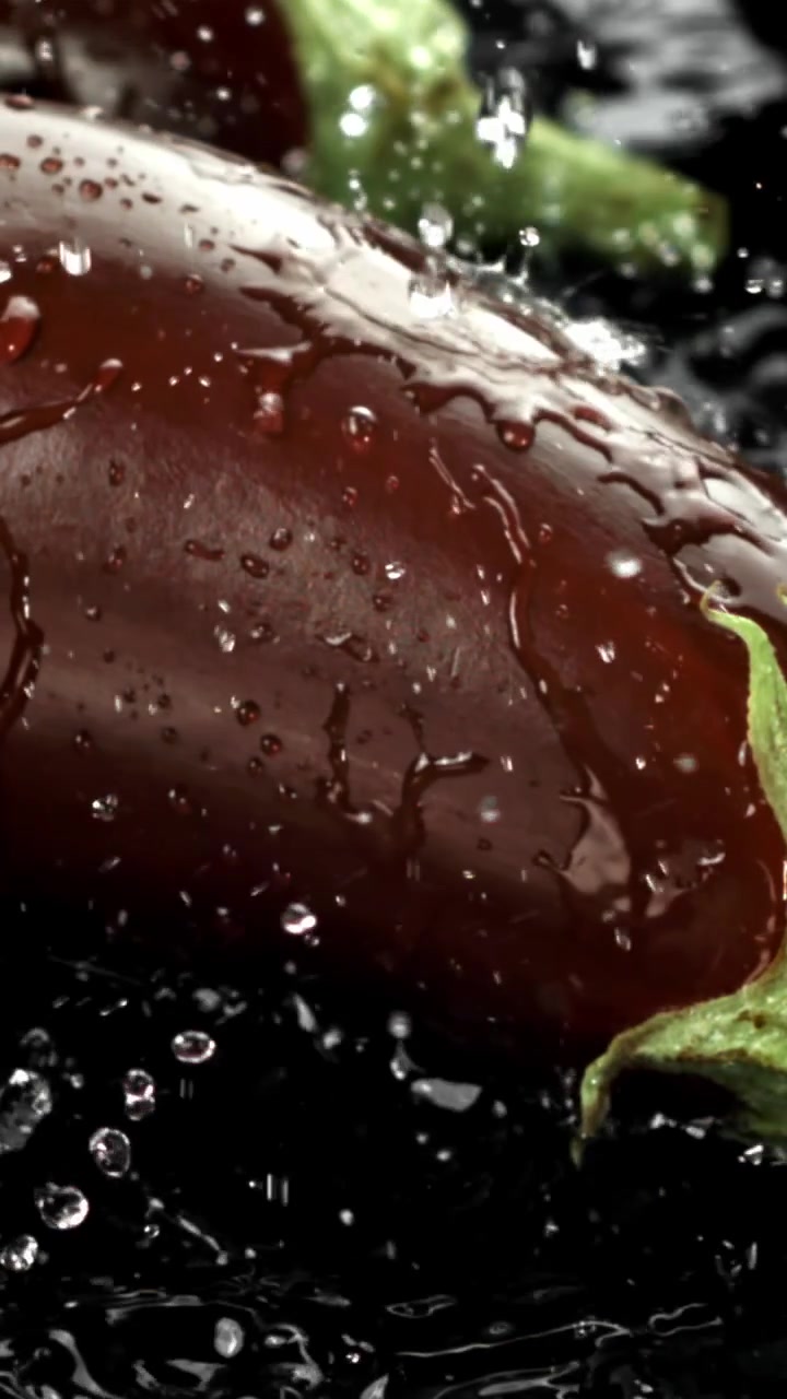 Närbild av vatten som stänker på en färsk aubergine