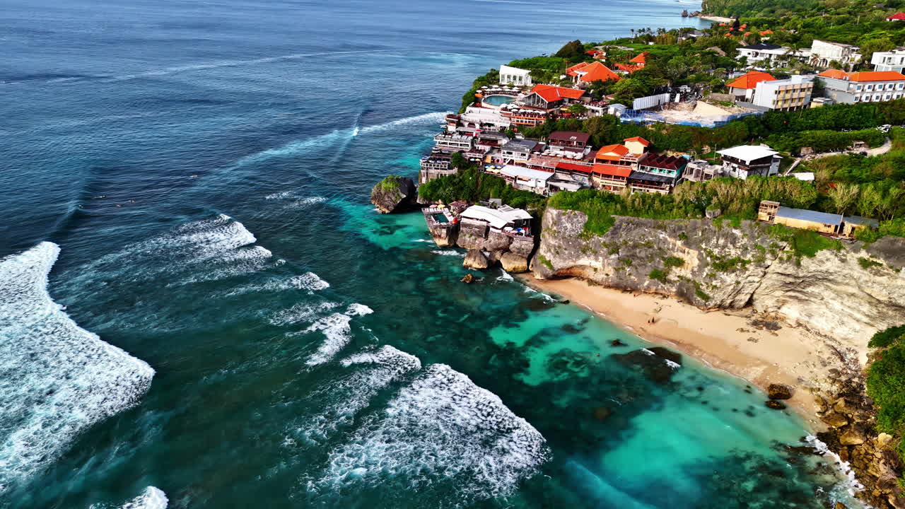 Coastal surfers resort with wavy sea in Indonesia, aerial view
