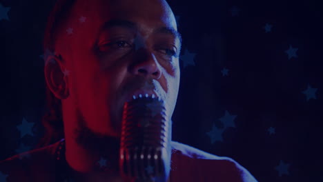 male singer performing with retro mic under red blue gels, using animated star overlays for music