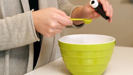 mujer añadiendo ingredientes al plato para hornear