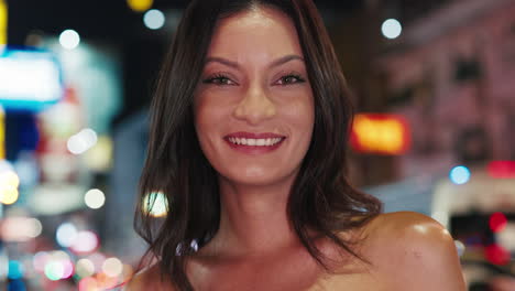 smiling woman in city at night
