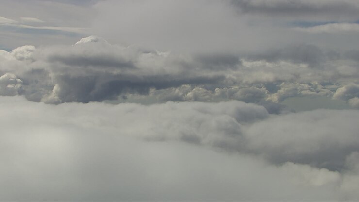 Aerial shot in between white fluffy clouds with clouds above and below